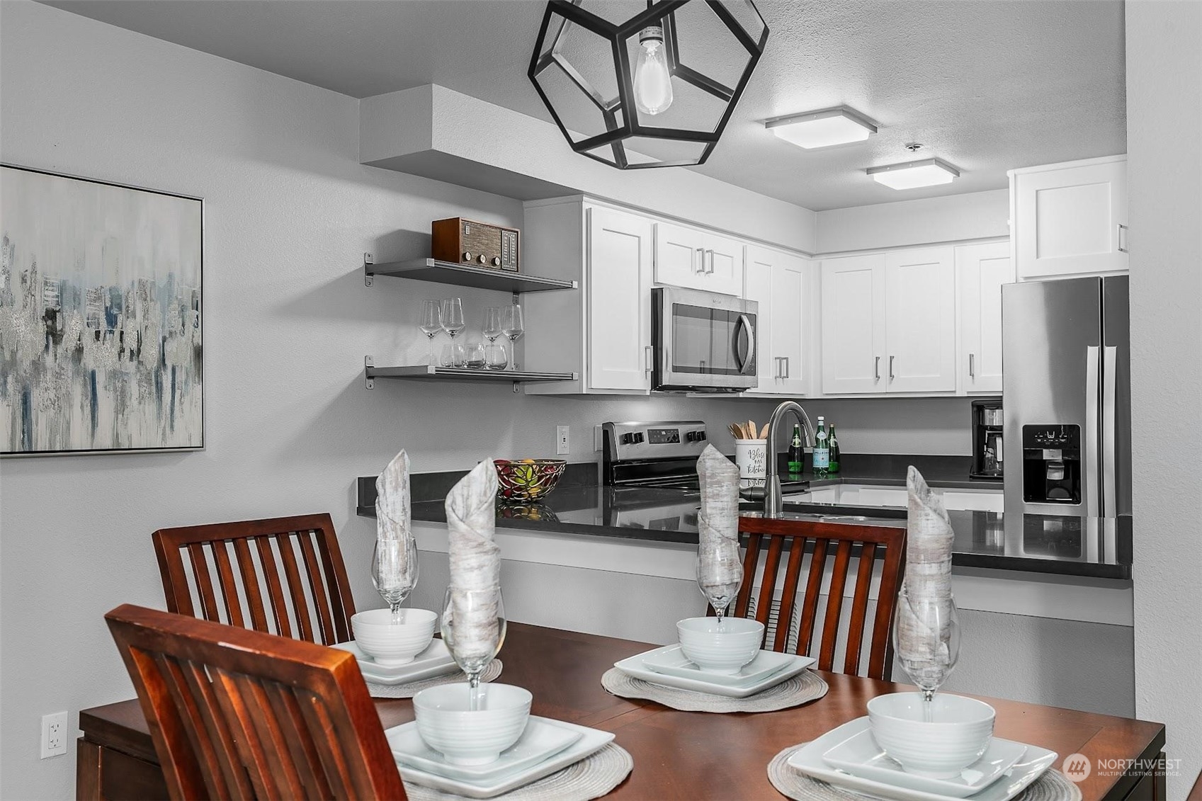 19404 Bothell Way Northeast, Unit B303 Bothell, WA 98011 - Photo 11 of 27 a kitchen with stainless steel appliances kitchen island granite countertop a table and chairs