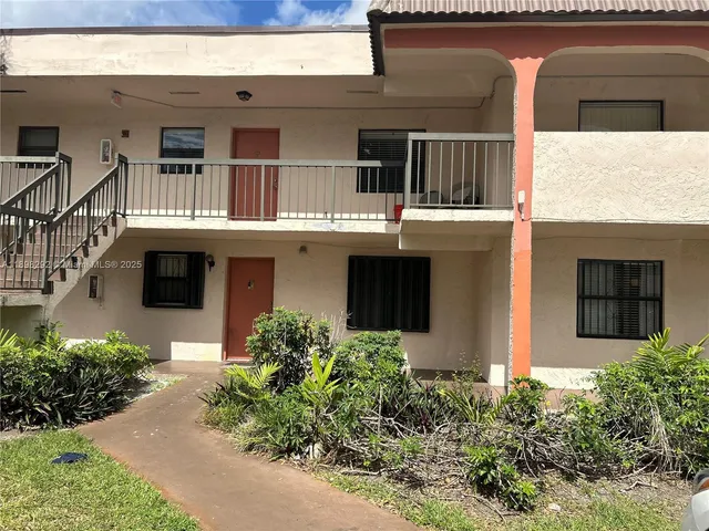 a front view of a house with plants