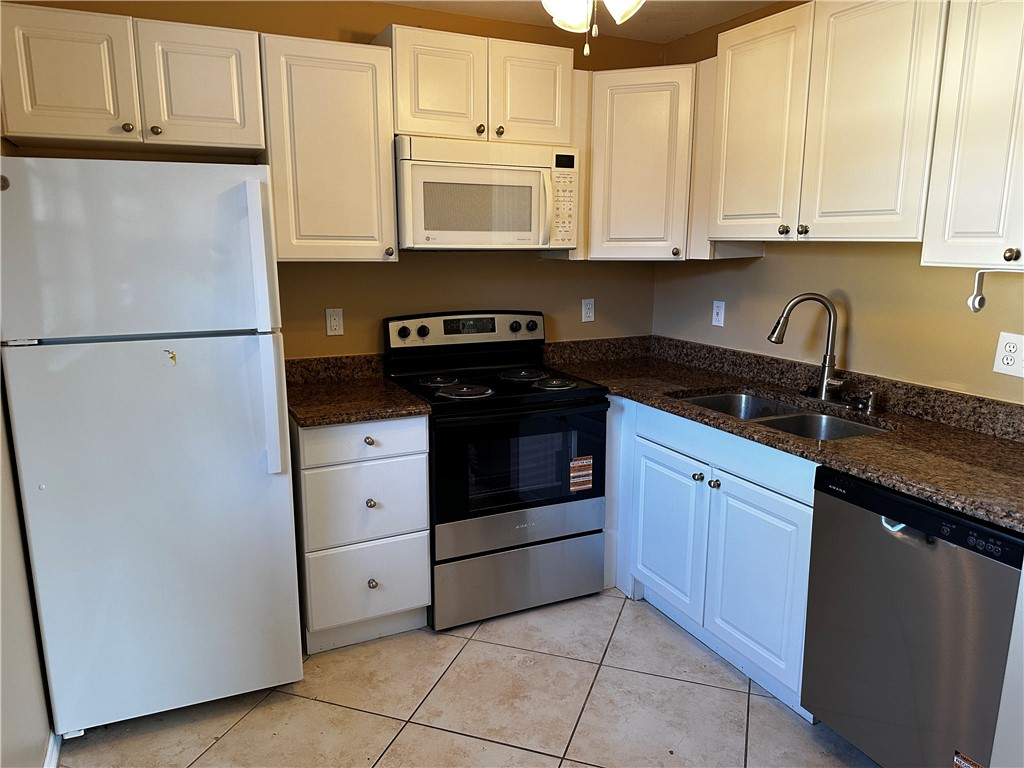 93 Spring Lake Drive, Unit 202 Vero Beach, FL 32962 - Photo 16 of 18 a kitchen with appliances cabinets and a counter top space