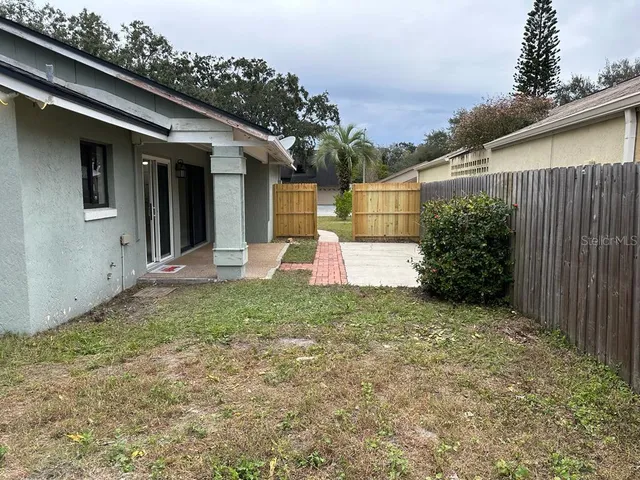 a backyard of a house with plants and tree