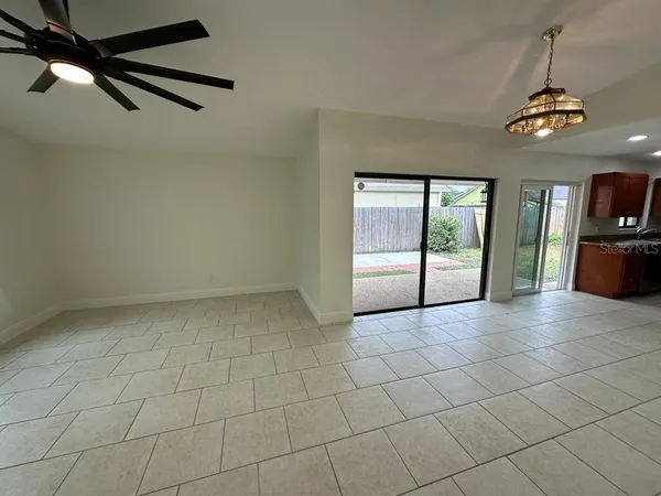 an empty room with windows and ceiling fan