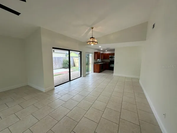 an empty room with windows and fireplace