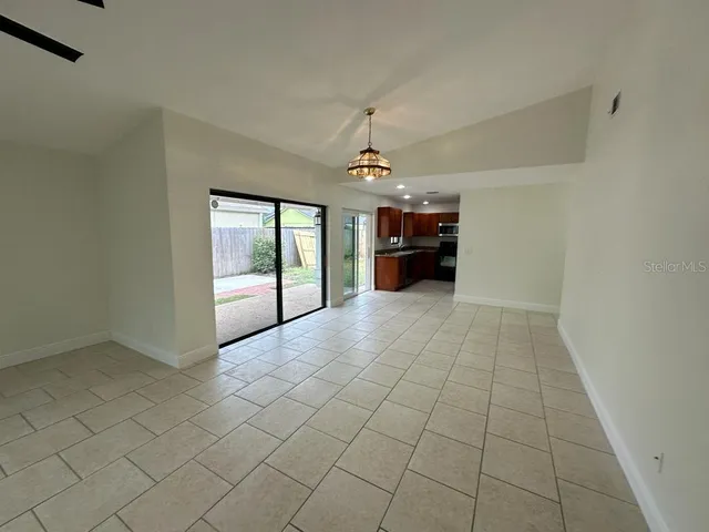 an empty room with windows and fireplace