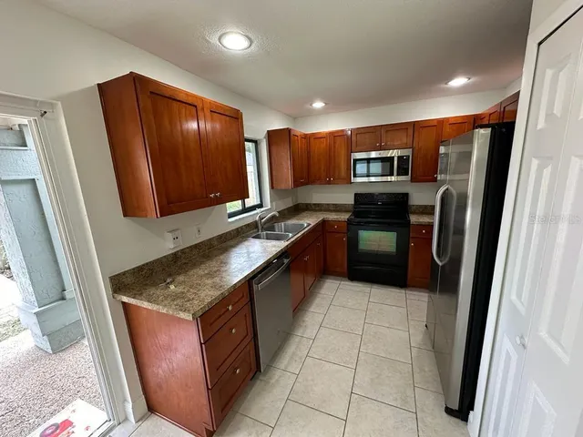 a kitchen with stainless steel appliances granite countertop a refrigerator and a stove