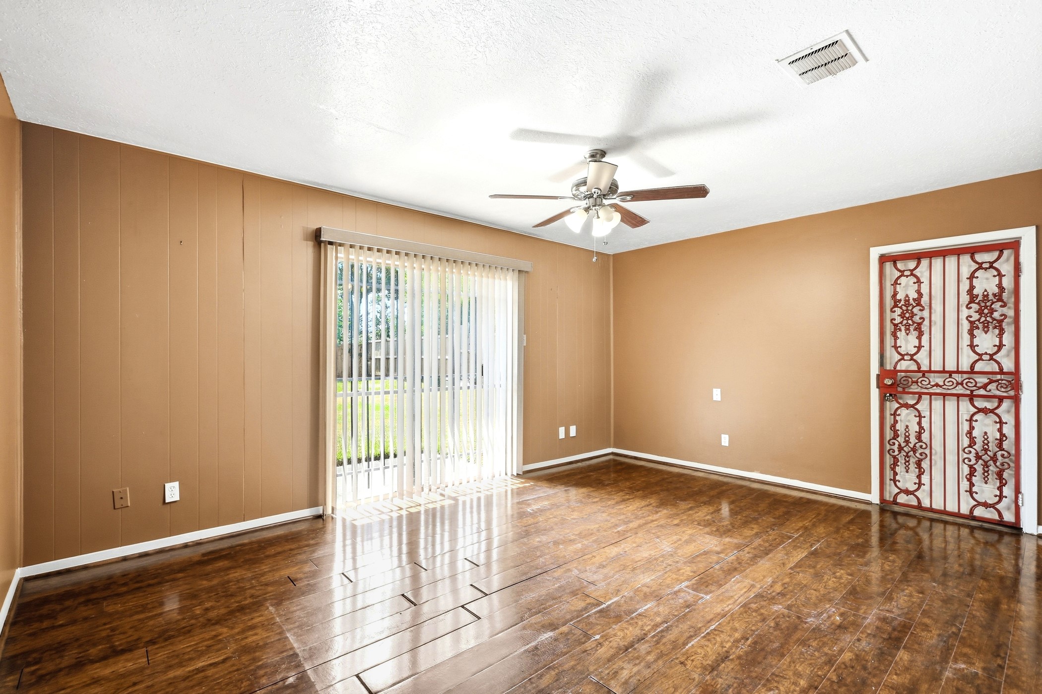 1507 Willow Rock Road Houston, TX 77088 - Photo 9 of 27 Light-filled living room with laminate flooring, a ceiling fan, and a sliding glass door that opens to the backyard.