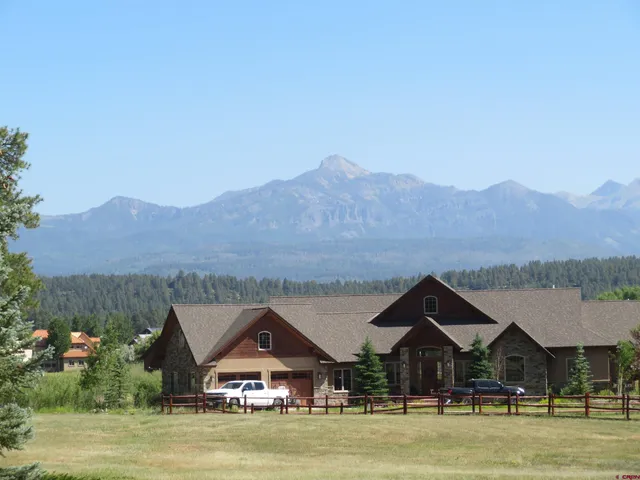 a front view of house with yard and mountain view in back