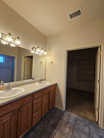 a spacious bathroom with a double vanity sink and a mirror