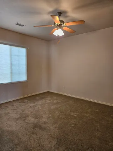 an empty room with a window and a fan