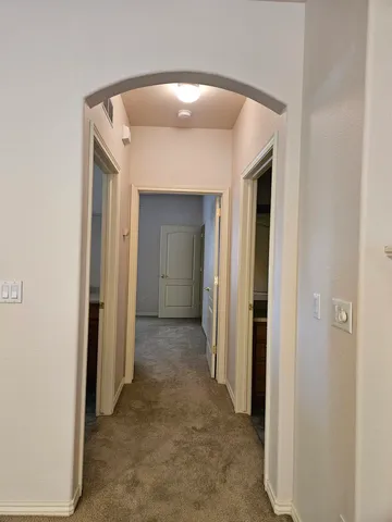 a view of a hallway with wooden shelves