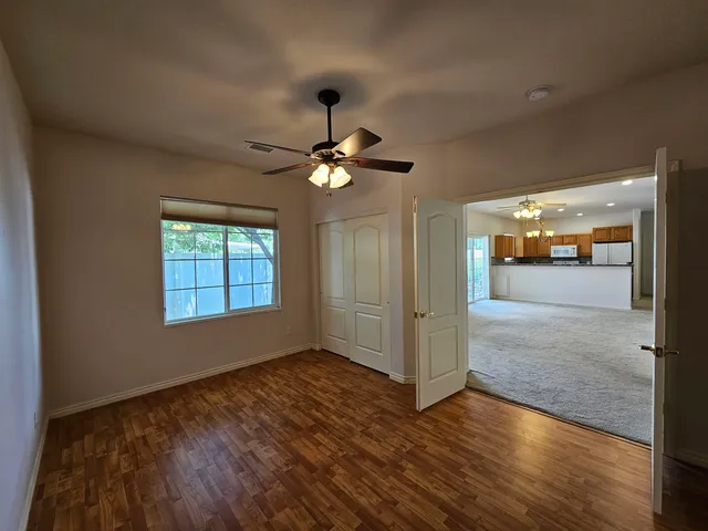 a view of a livingroom with a ceiling fan window and wooden floor