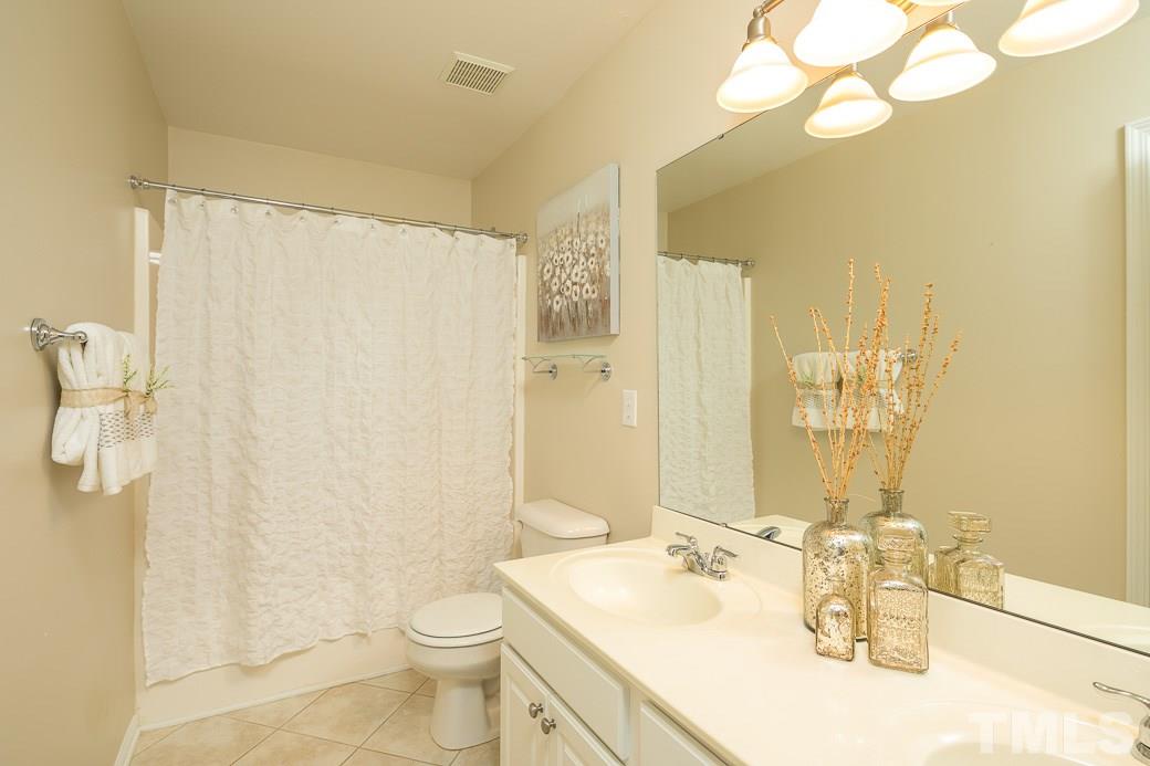 3315 Colorcott Street Raleigh, NC 27614 - Photo 14 of 21 a bathroom with a sink a toilet and shower curtain