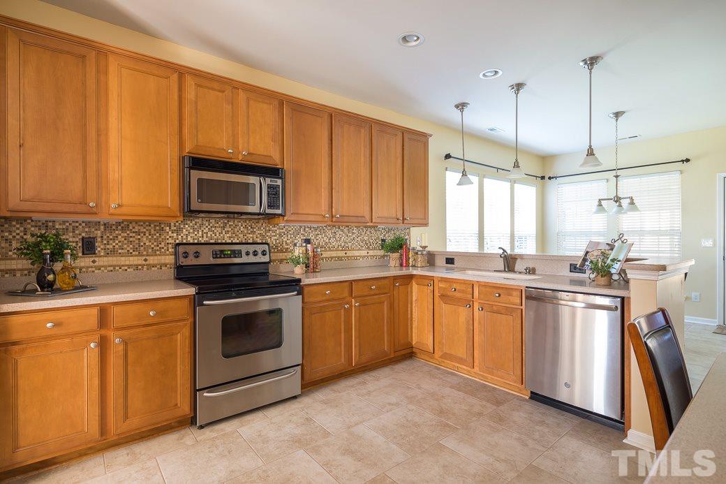 3315 Colorcott Street Raleigh, NC 27614 - Photo 3 of 21 a kitchen with stainless steel appliances granite countertop a stove top oven a sink dishwasher and a microwave oven with cabinets