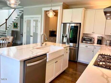 3015 Freeman Farm Way Rolesville, NC 27571 - Photo 16 of 50 a kitchen with stainless steel appliances kitchen island granite countertop a refrigerator a sink dishwasher and white cabinets with wooden floor