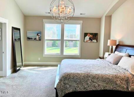 3015 Freeman Farm Way Rolesville, NC 27571 - Photo 26 of 50 a bedroom with a large bed and a chandelier
