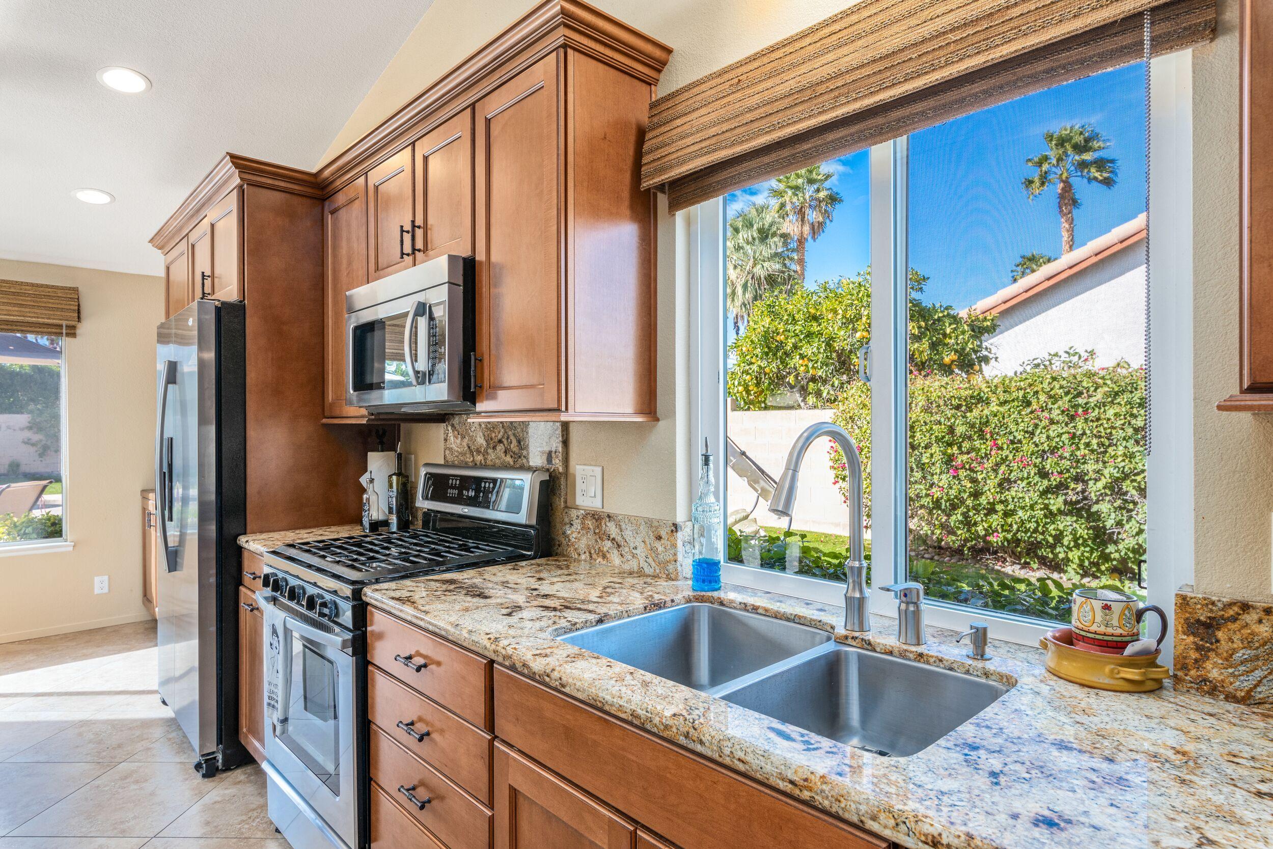 39795 Regency Way Palm Desert, CA 92211 - Photo 19 of 39 a kitchen filled with granite countertop a sink stove and cabinets