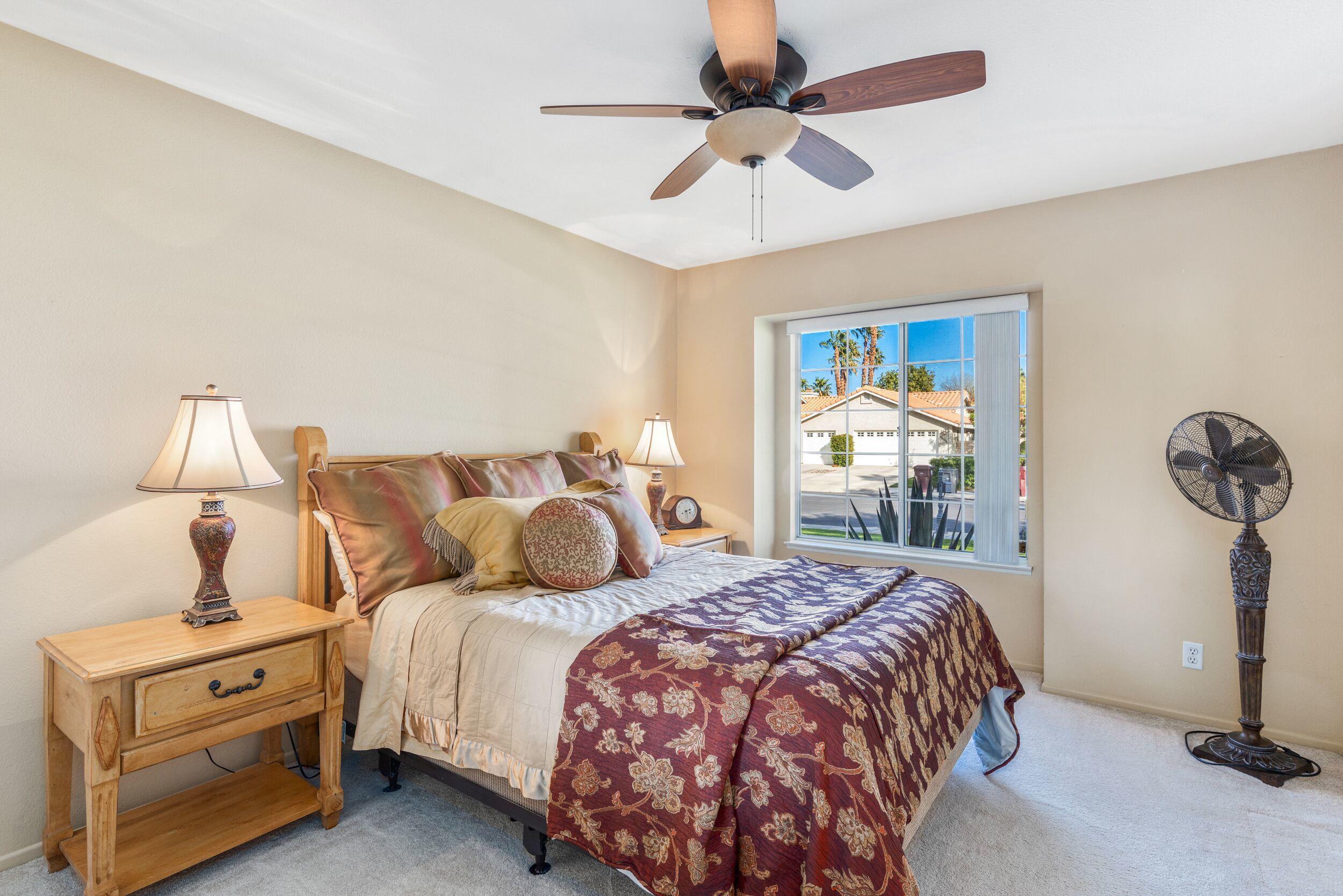 39795 Regency Way Palm Desert, CA 92211 - Photo 29 of 39 a bedroom with a bed and a chandelier