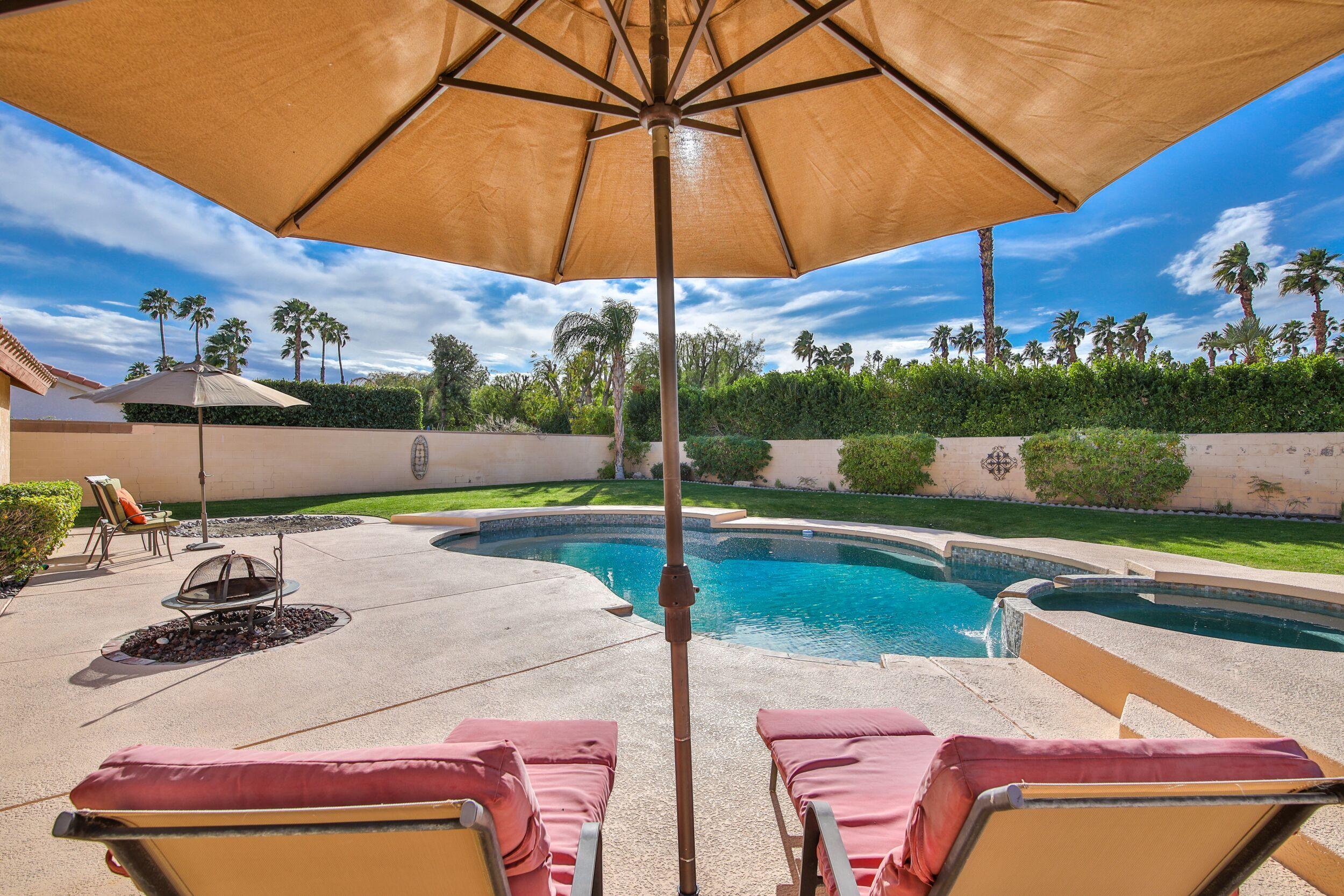 39795 Regency Way Palm Desert, CA 92211 - Photo 37 of 39 a view of a patio with a table chairs under an umbrella