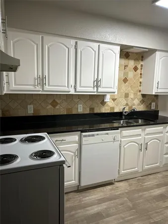 a kitchen with granite countertop white cabinets and black appliances