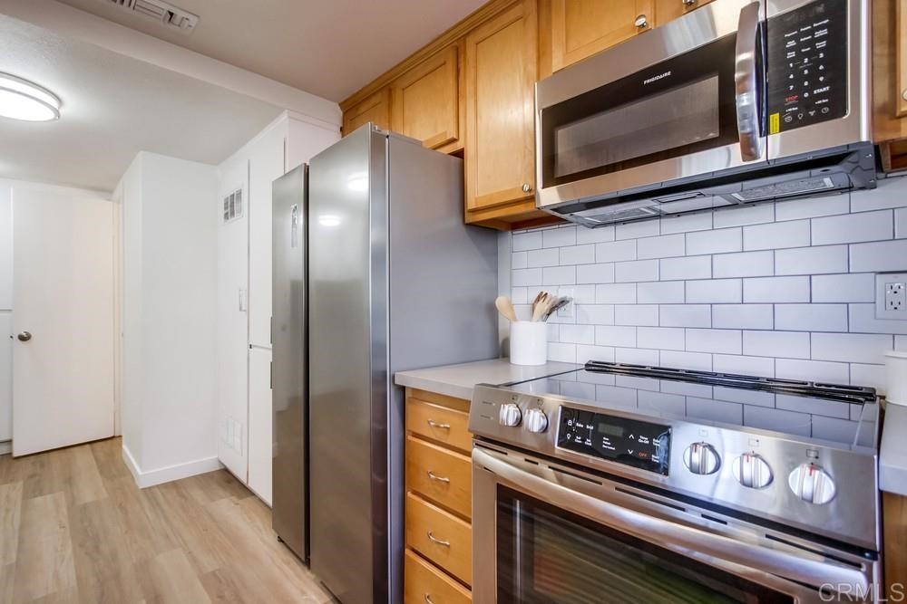 11941 Royal Road, Unit A El Cajon, CA 92021 - Photo 3 of 28 a kitchen with stainless steel appliances granite countertop a stove and a microwave