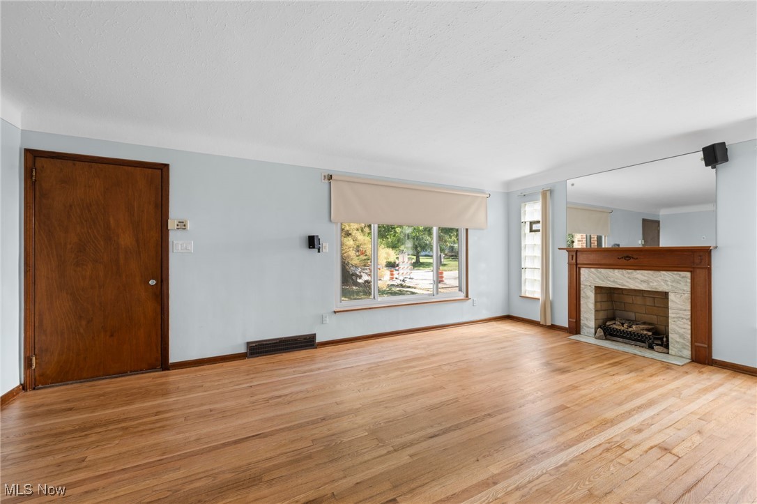 18122 Nottingham Road Cleveland, OH 44119 - Photo 3 of 29 Unfurnished living room featuring a tile fireplace and wood finished floors