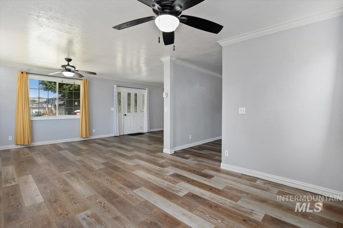 1940 Q Street Heyburn, ID 83336 - Photo 8 of 30 Spacious room featuring wood-finish flooring, light gray wall paint, and white baseboards