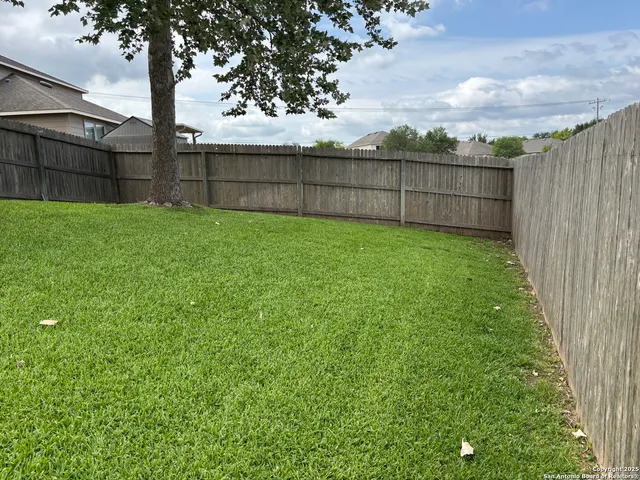 a view of a backyard with a fence