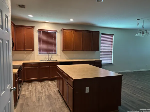 a kitchen with a sink cabinets and wooden floor