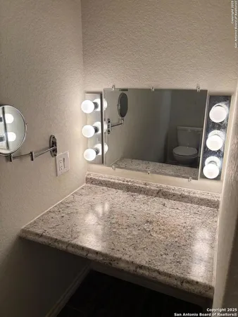 a bathroom with a granite countertop sink and vanity