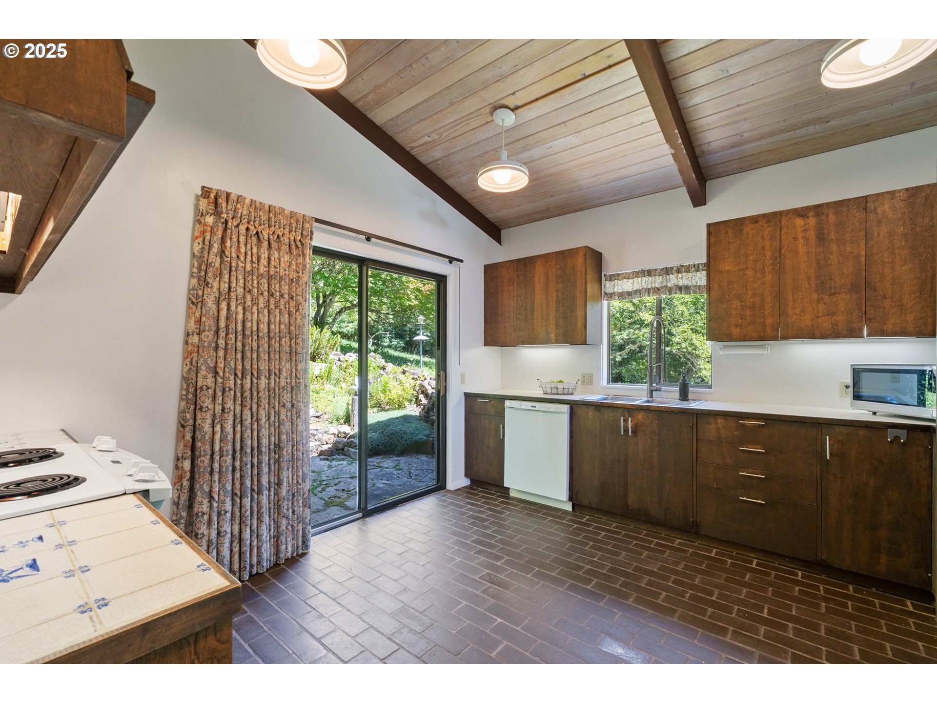 56100 High Point Road Otis, OR 97368 - Photo 16 of 47 a kitchen with stainless steel appliances kitchen island granite countertop a refrigerator a sink dishwasher and wooden cabinets with a workspace