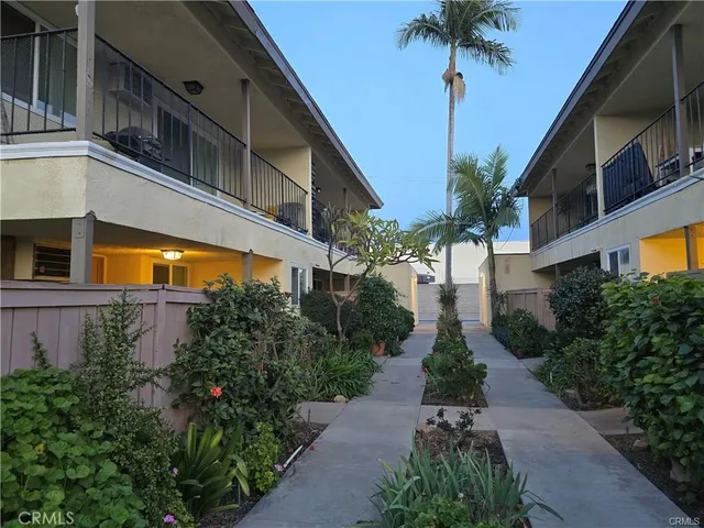 a front view of a house with a yard and potted plants