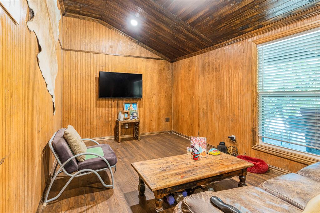 548 Elston Drive Dallas, TX 75232 - Photo 3 of 18 Living area with vaulted ceiling, wood finished floors, wood walls, and wood ceiling