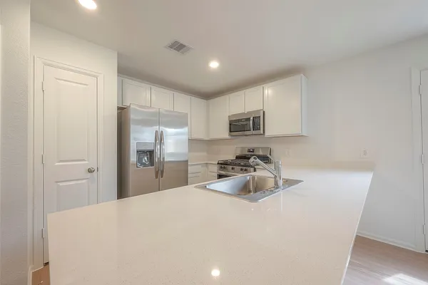 a kitchen with sink cabinets and refrigerator