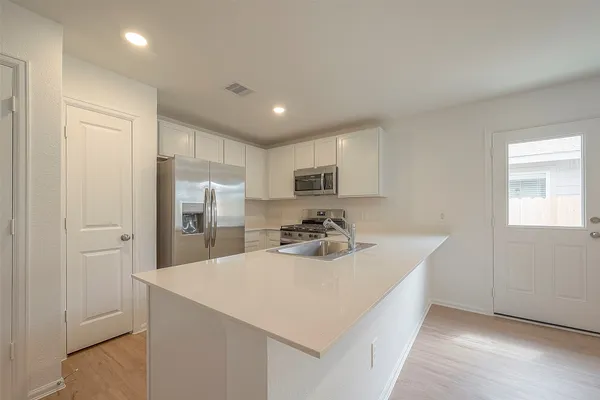 a kitchen with refrigerator and cabinets