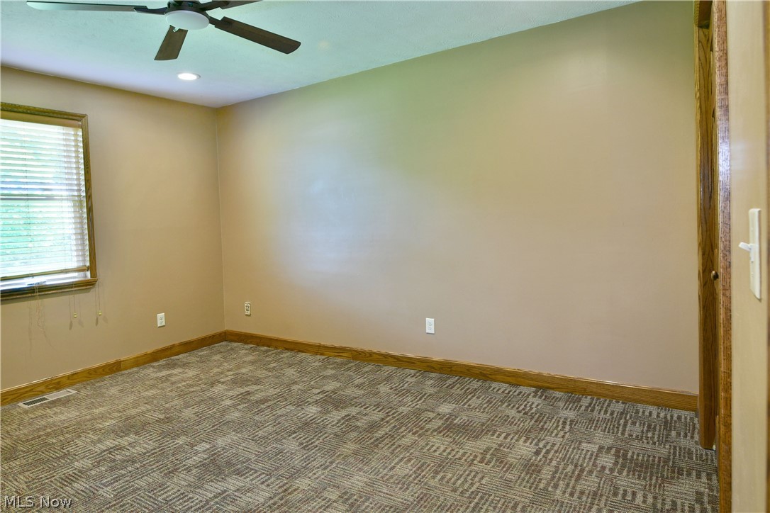 754 Warner Road Hubbard, OH 44425 - Photo 36 of 46 Room featuring patterned carpet, light tan walls, and a ceiling fan with integrated lighting