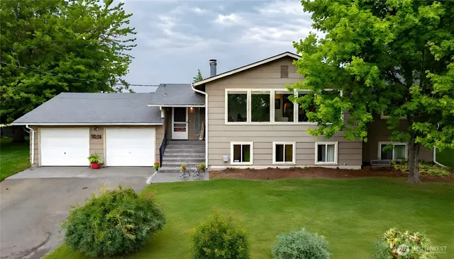 a front view of a house with a garden and plants