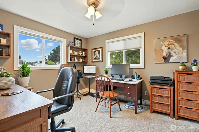 a view of a workspace with furniture and a window