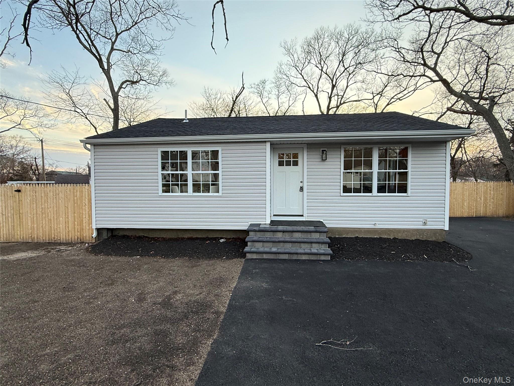 View of front facade with a shingled roof and entry steps