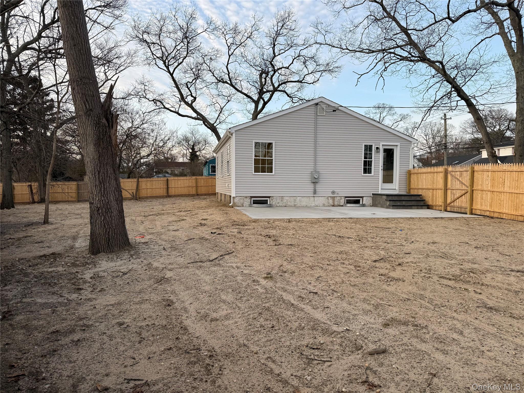 661 College Road Farmingville, NY 11738 - Photo 15 of 19 Back of house with a patio, a fenced backyard, and entry steps