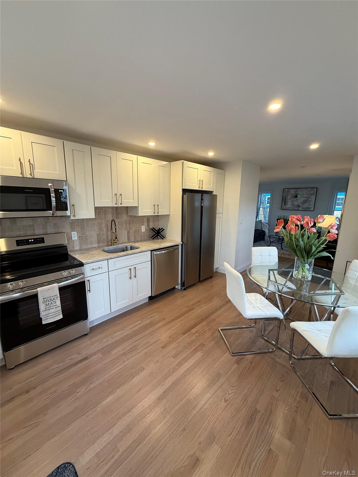661 College Road Farmingville, NY 11738 - Photo 4 of 19 Kitchen with stainless steel appliances, white cabinets, light wood finished floors, recessed lighting, and decorative backsplash