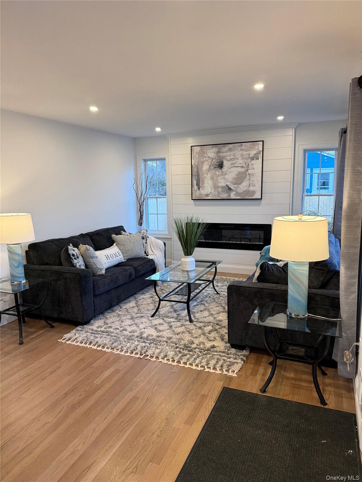 661 College Road Farmingville, NY 11738 - Photo 5 of 19 Living room featuring wood finished floors, a glass covered fireplace, and recessed lighting