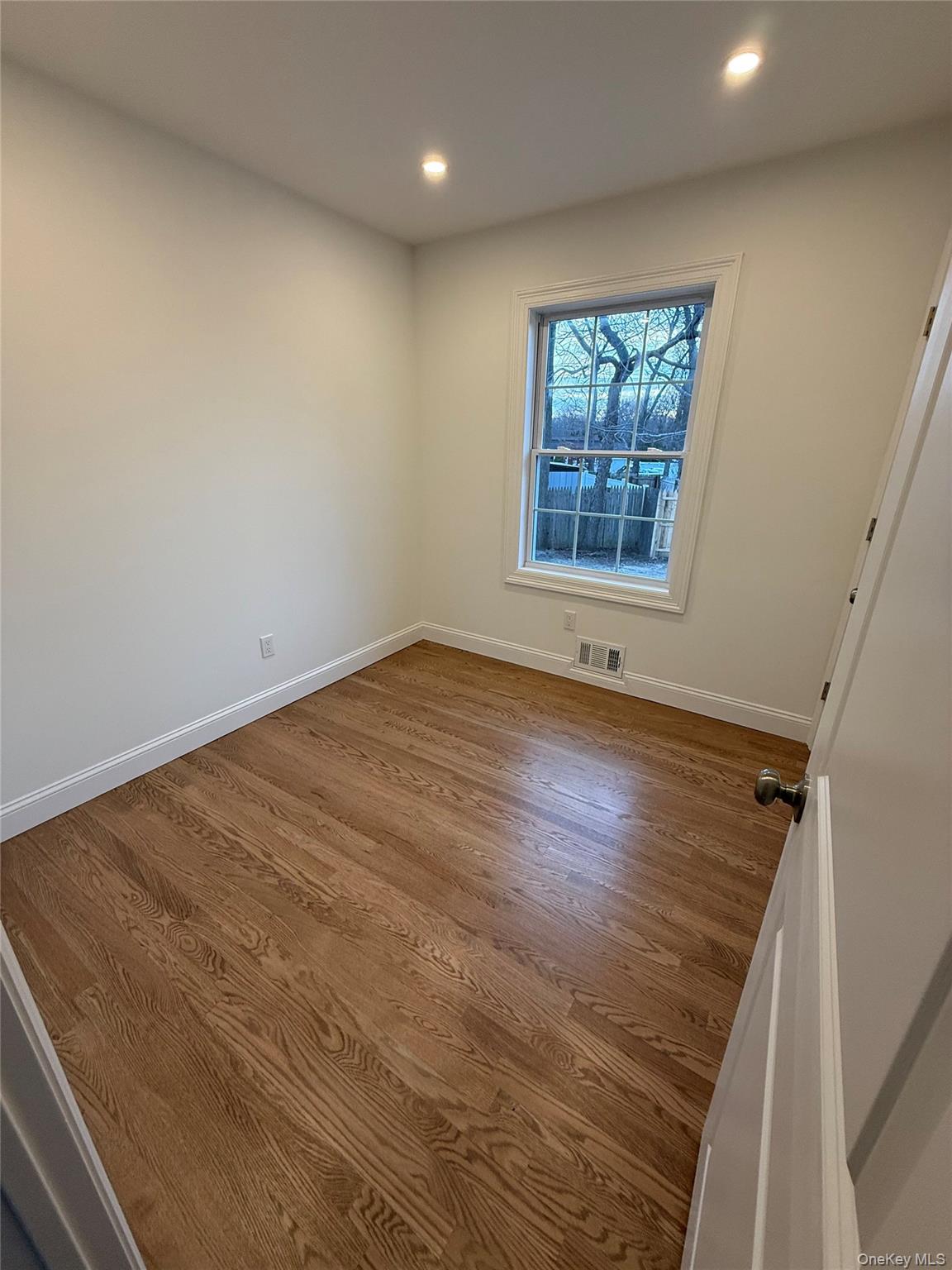 661 College Road Farmingville, NY 11738 - Photo 8 of 19 Empty room featuring dark wood-style floors and recessed lighting