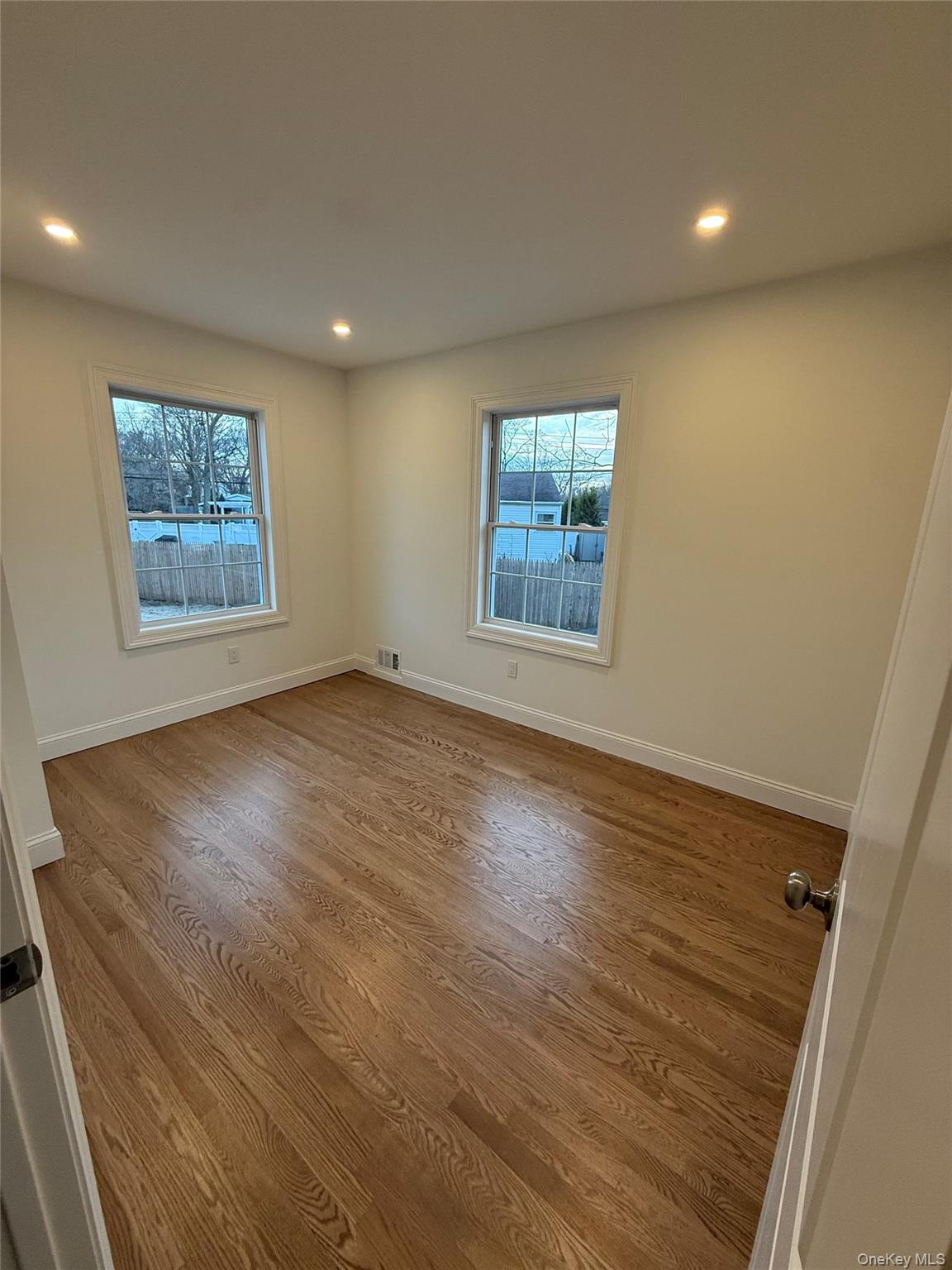 661 College Road Farmingville, NY 11738 - Photo 9 of 19 Spare room featuring dark wood-style flooring, plenty of natural light, and recessed lighting