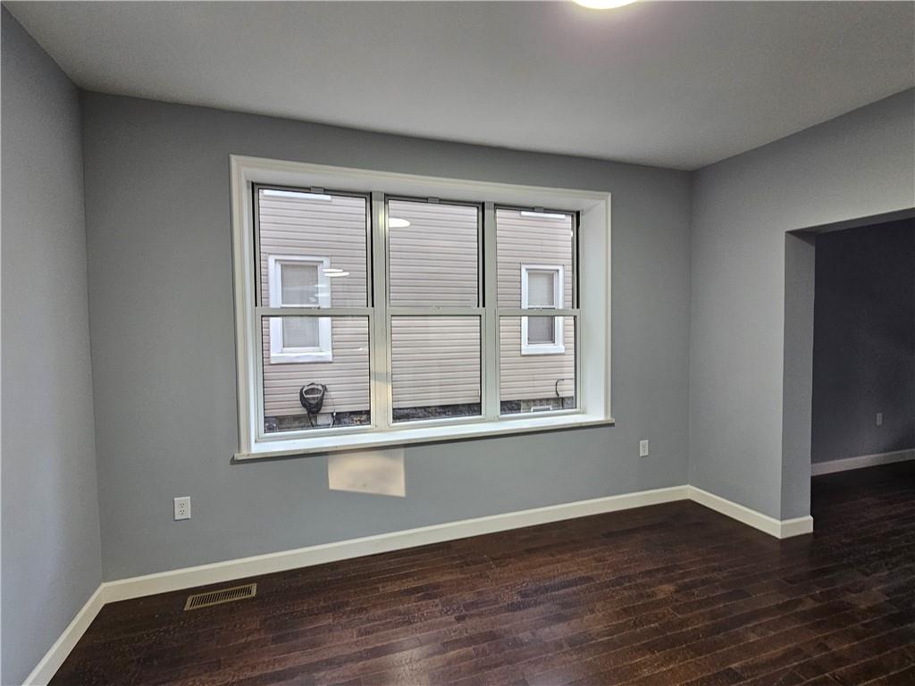 516 Jackson Street Rochester, PA 15074 - Photo 9 of 30 a view of an empty room with wooden floor and a window
