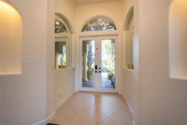 a dining room with wooden floor a chandelier a glass table and chairs