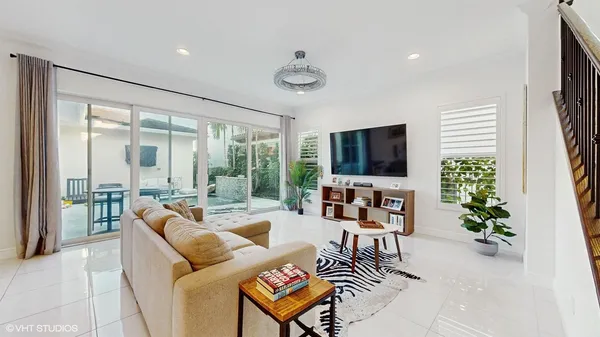 a living room with furniture a flat screen tv and a large window