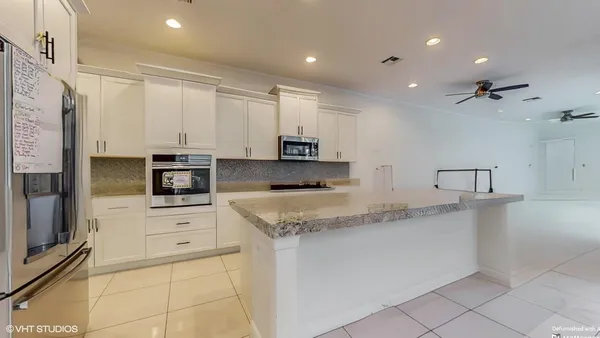 a kitchen with stainless steel appliances granite countertop a refrigerator and a stove