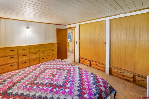 a bedroom with a large bed and a dresser