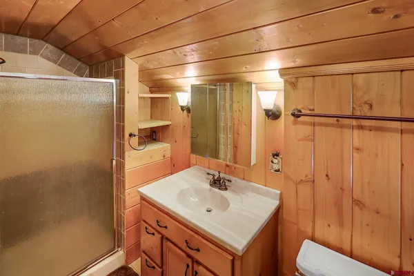 a bathroom with a sink a toilet and shower