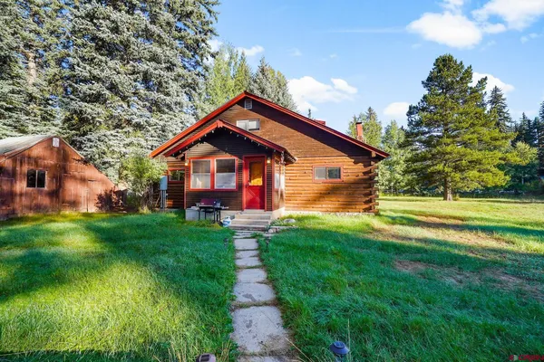 a view of backyard of house with green space