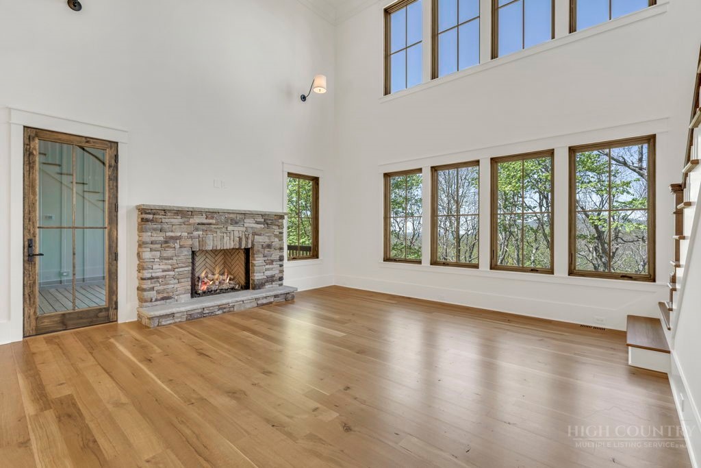 536 Boone Ridge Lane Boone, NC 28607 - Photo 8 of 50 a view of an empty room with wooden floor and a fireplace